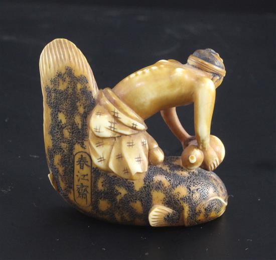 A Japanese ivory netsuke of a man riding a cat fish, 19th century, signed Shunkosai, 5cm